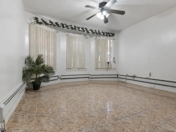 Living room with tile flooring and ceiling fan at 33 Vreeland Ave, Passaic NJ